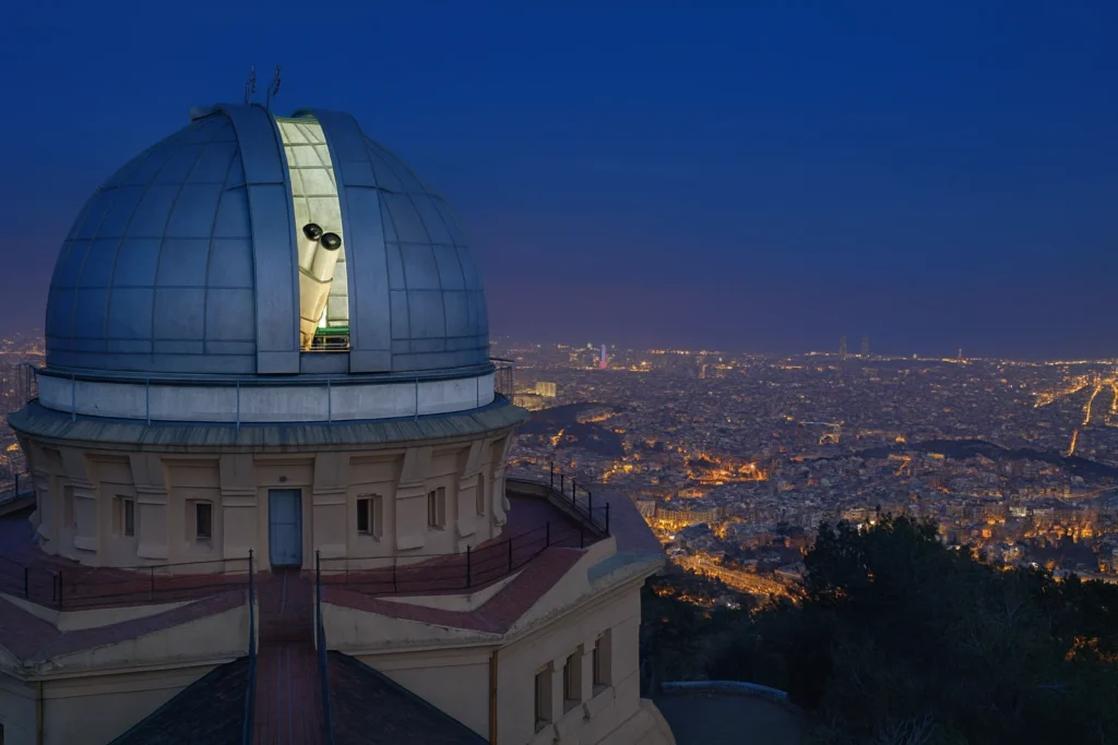 Personas brindando al atardecer en un barco frente al skyline de Barcelona
